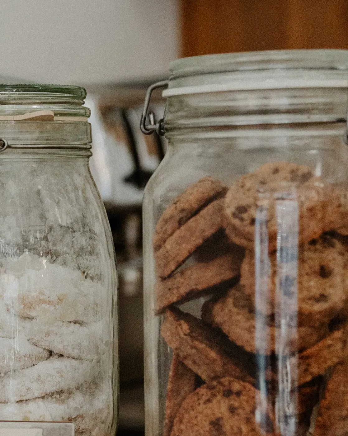 Két befőttesüveg aprósüteménnyel a fa pulton