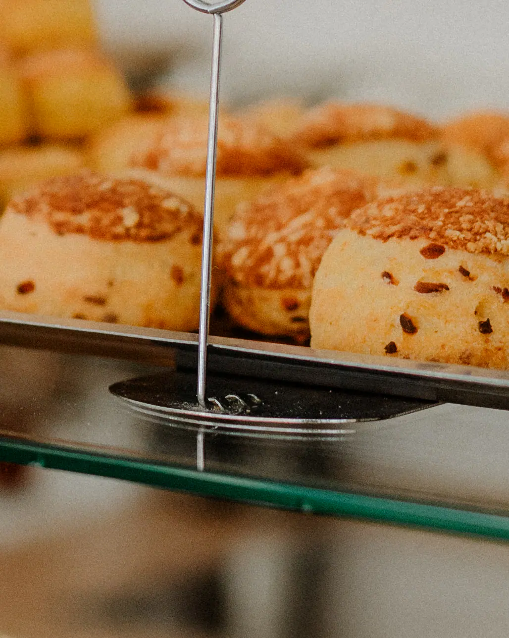 Aranybarna pogácsák tálcán a pult üvegpolcán